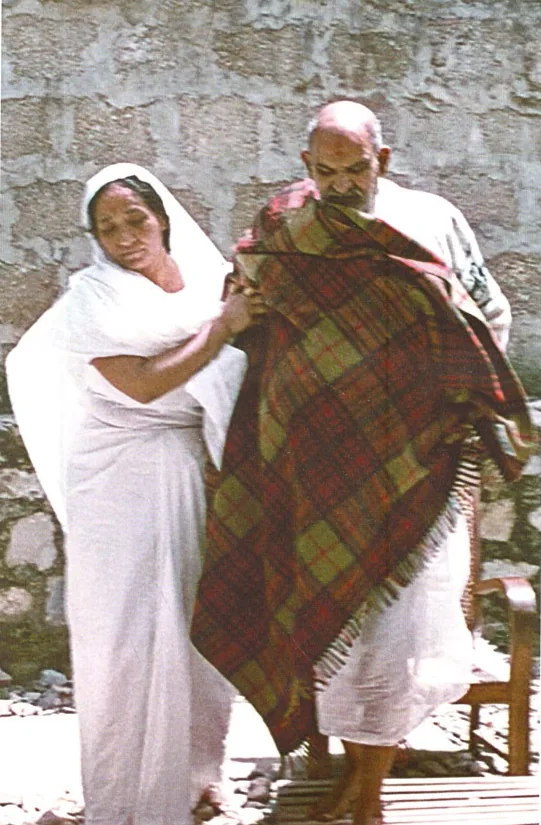 Shri Siddhi Ma wrapping a blanket around Neem Karoli Baba